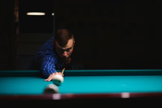 the player takes aim at the ball in Billiards