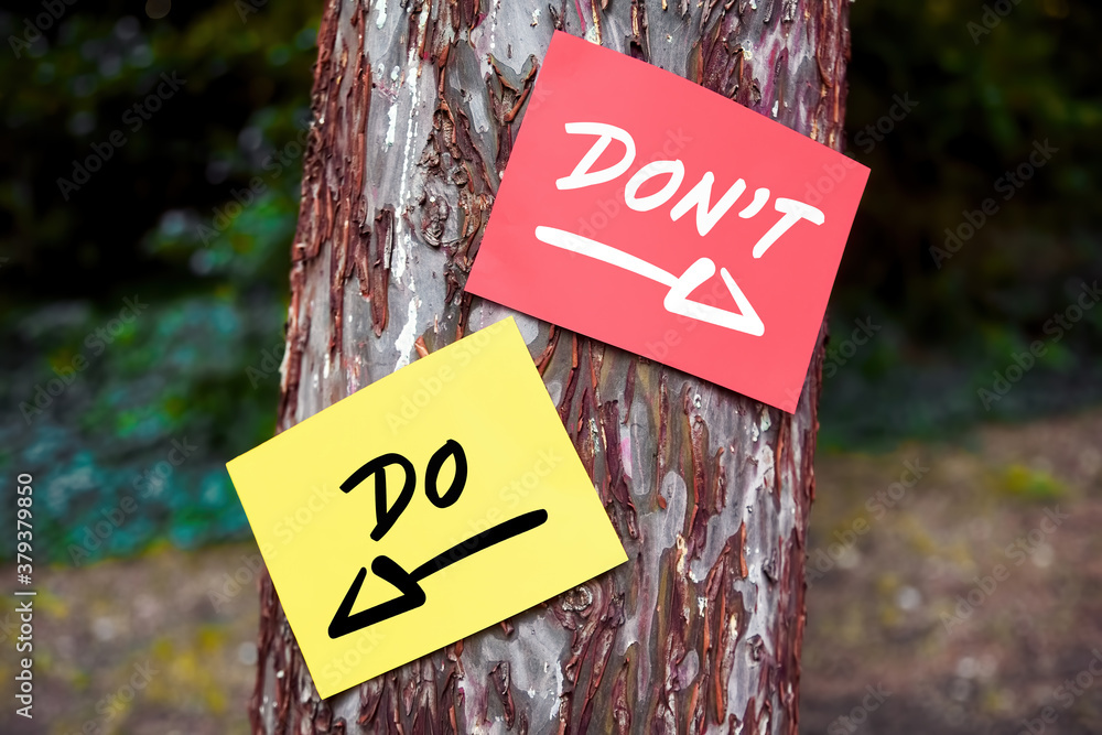 Poster do and don't words written on papers on a tree with arrow signs. dilemma between what to to or not t