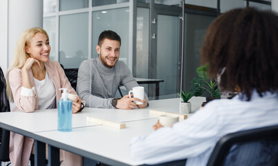 Fototapeta premium Modern office, coffee break and health protection. Multiracial employees have break in restroom