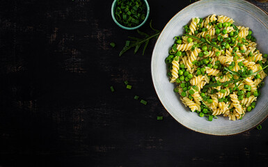 Obraz na płótnie Canvas Vegan salad. Fusilli pasta with green peas and onions. Italian food. Top view. Flat lay.
