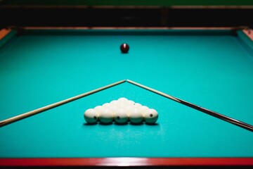 game of billiards the hand of a man with a billiard cue aims at a billiard ball