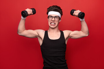 Fototapeta na wymiar Young nerd exercising with dumbbells