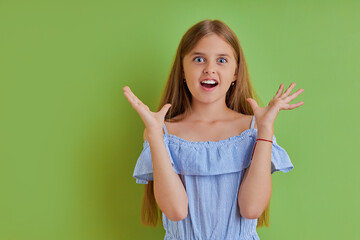 surprised girl emotionally react on news, she expresses her emotions at camera, rised hands, look at camera