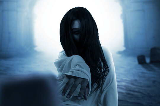 Scary ghost woman crawling with a graveyard background
