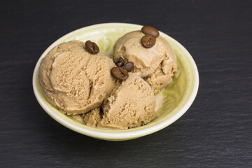 fresh coffee ice cream scoops in a bowl with coffee beans