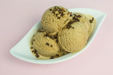 fresh coffee ice cream scoops in a bowl with coffee bean pieces