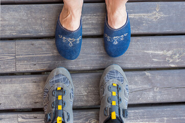 Top view on female feet wearing slippers and male feet wearing cycling shoes standing on an old...