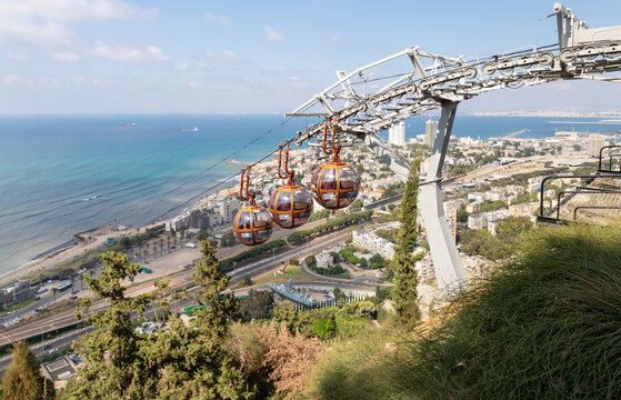 The cabins of the cable car move up towards the upper station on Mount Carmel against the background of the lower city and the Mediterranean Sea in Haifa in northern Israel