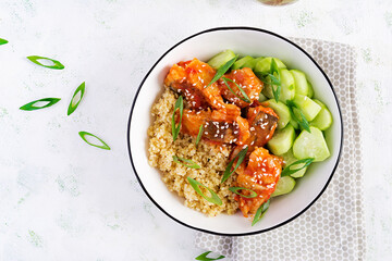 Fish fillet cooked in tomato sauce with bulgur and cucumber on a plate on a light background. Healthy eating concept. Easy cooking. Top view, flat lay, copy space