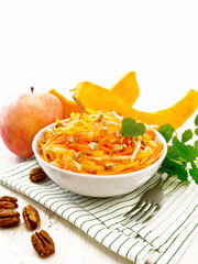 Salad of pumpkin and apple in bowl on white board