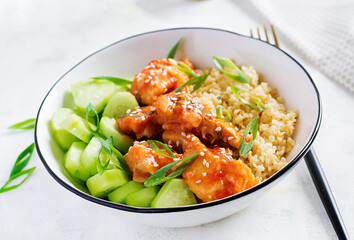 Fototapeta na wymiar Fish fillet cooked in tomato sauce with bulgur and cucumber on a plate on a light background. Healthy eating concept. Easy cooking.