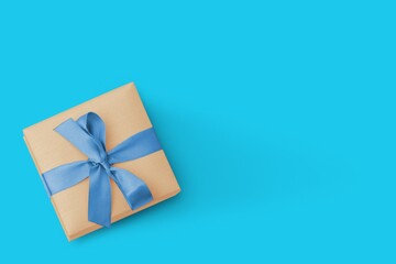 Fototapeta na wymiar Gift box with ribbon on a blue background. Place for text