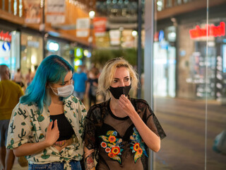 Shot of two women wearing medical masks talking to each other  - new normal