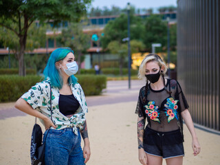 Shot of two women wearing medical masks talking to each other  - new normal