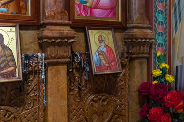 Numerous donations from believers hang near the icon in the Church of the Apostles located on the...