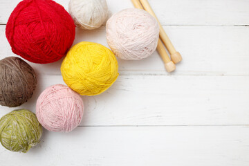 Fototapeta na wymiar Knitting wool and crochet hook on white wooden background. Top view, flat lay, copy space. Female hobby. Frame of yarn.
