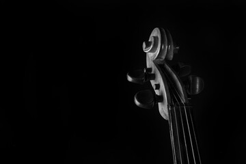 Details of an old and beautiful violin on a rustic wooden surface and black background, low key...
