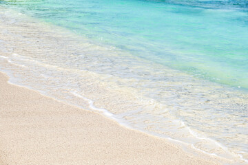 Fototapeta na wymiar Wave of blue ocean on sandy white beach, texture background, travel concept