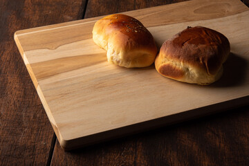 Homemade bread stuffed with cheese and ham with black background. Low key image, selective focus.