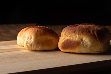 Homemade bread stuffed with cheese and ham with black background. Low key image, selective focus.