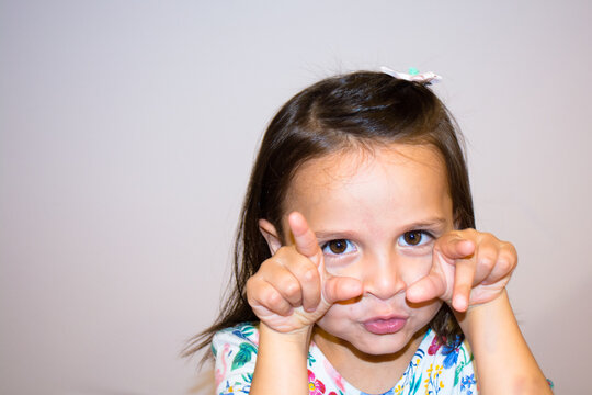 Portrait of a five year old girl making funny faces
