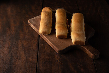 Homemade bread stuffed with ground mortadella and tomato sauce with black background. Low key...