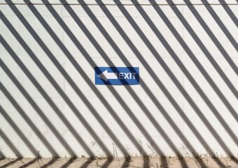 Fototapeta premium Segnale di uscita su uno sfondo murale e texture di ombre a strisce