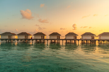 Tropical Water villas with reflection on Maldives island in sunrise time, holiday vacation concept, summer  background