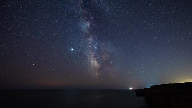 Amazing time lapse with Milky Way galaxy and plane trails at a rocky coastline, Black sea coast, Bulgaria