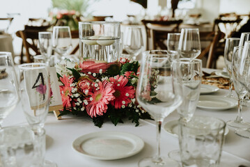 table setting for a wedding reception. restaurant table with a natural pink gesbera centerpiece