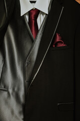 suit and tie. detail of the burgundy tie and handkerchief of a groom suit