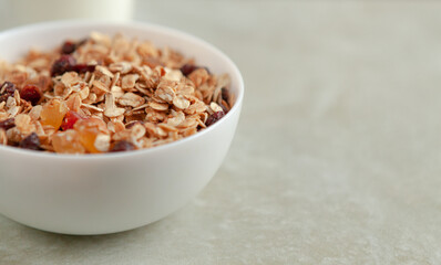 Bowl with muesli on a beige table with place for text