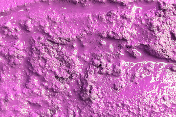 Liquid uneven abstract background. The surface is purple, rough paint flowing with bubbles. Bright texture wallpaper.