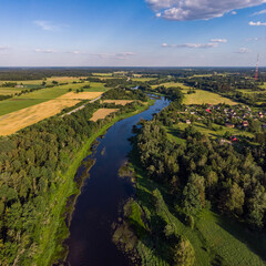 Fototapeta na wymiar Areal countryside view o river Venta flowing through lovely environment with trees on a warm summer day.