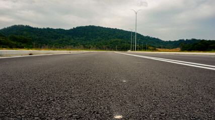low angle shot of asphalt road and mountain in background in Malaysia