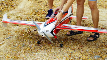 Red and white color RC plane on the ground for take off.
