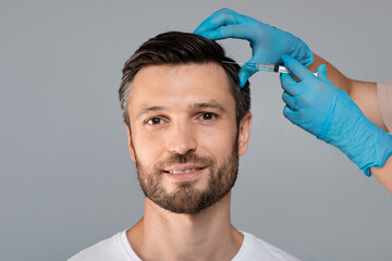 Handsome man having hair treatment at salon