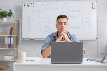 Communicate with students online remotely and video call with teacher. Concentrated man looking at...