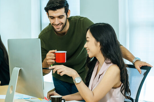 two young business people in smart casual discuss project look at computer screen in meeting room office, intern new employee, digital online marketing, business meeting startup concept