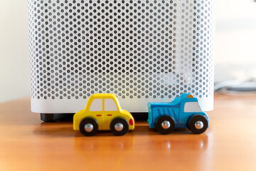 An air purifier with a toy car placed nearby. eco-friendly car concept