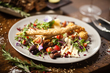 Cheese platter for two: Goat cheese cream, gorgonzola, camembert, grissini and fig jam. Delicious healthy Italian traditional food closeup served for lunch in modern gourmet cuisine restaurant