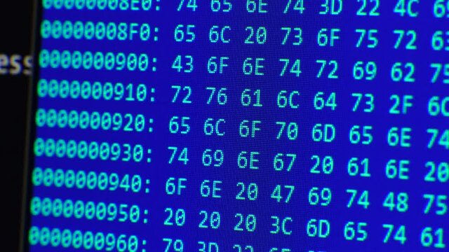Close up on computer screen binary code on blue background.