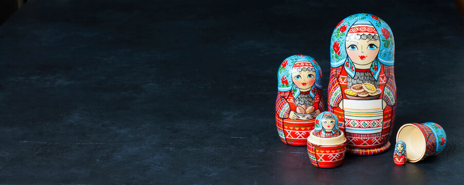 Five red matryoshka. Traditional Russian toy. Copy space. Black concrete background