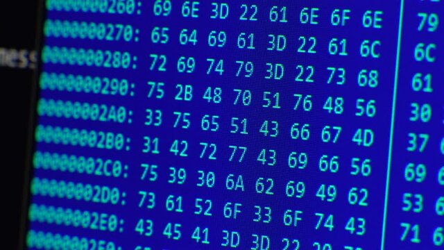 Close up on computer screen binary code on blue background.