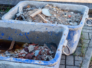Mörtelwannen mit Bauschutt auf einer Baustelle