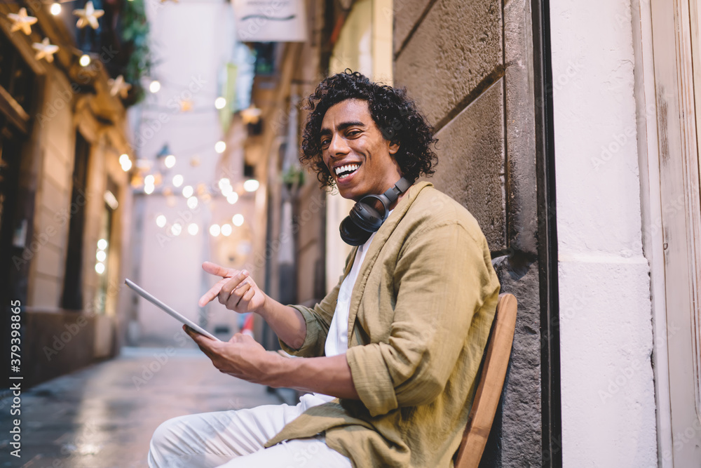 Aufkleber cheerful happy hipster guy pointing on digital tablet enjoying good internet connection for chatting