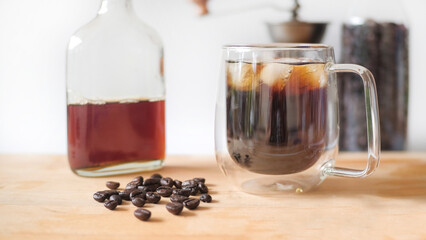 Ice cold brew coffee on wooden table and white background.