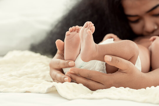 Selective focus on hands holding infant's feet