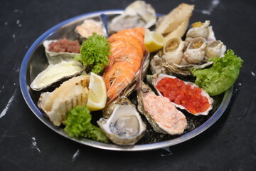 a plate of assorted seafood on a black background