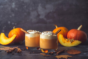 Pumpkin latte drink. Autumn coffee with spicy pumpkin flavor and cream on a dark background....